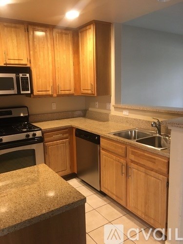 A kitchen with wooden cabinets and granite countertops.