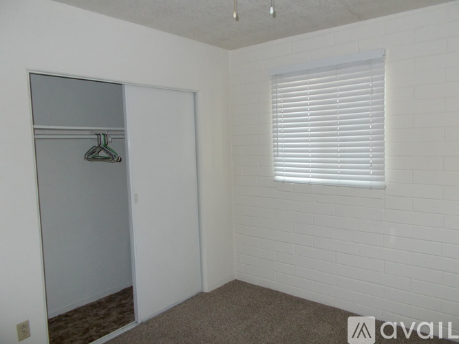 A room with a white door and a window with blinds.