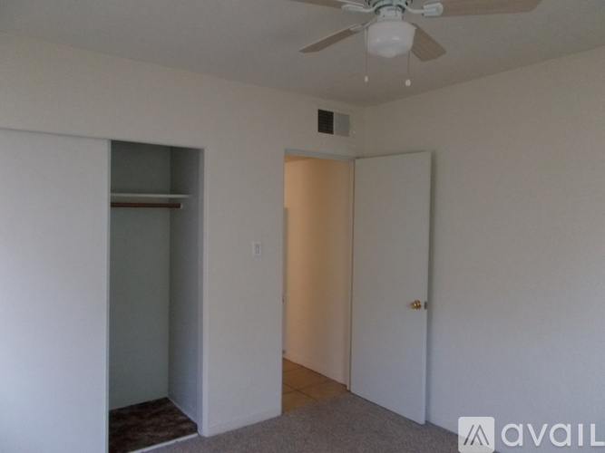 A room with a ceiling fan and a door.