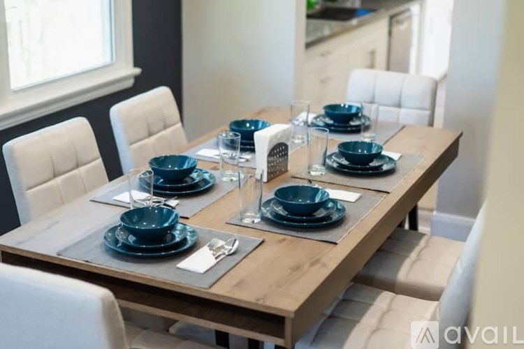 A dining table set with blue plates and glasses.