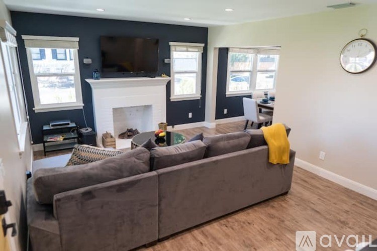 A living room with a grey couch and a fireplace.