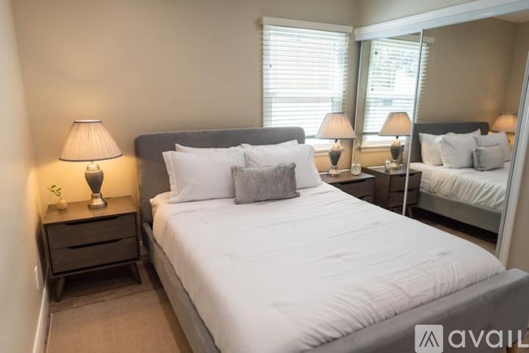 A bedroom with a large bed and two nightstands with lamps.