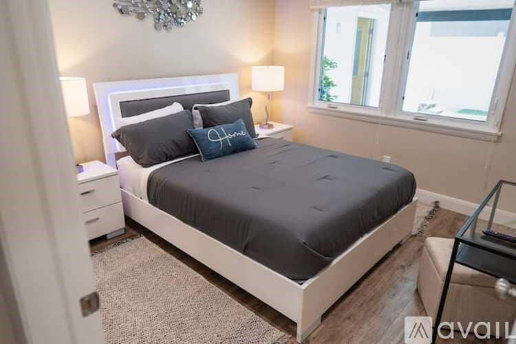 A bedroom with a large bed and a chandelier.