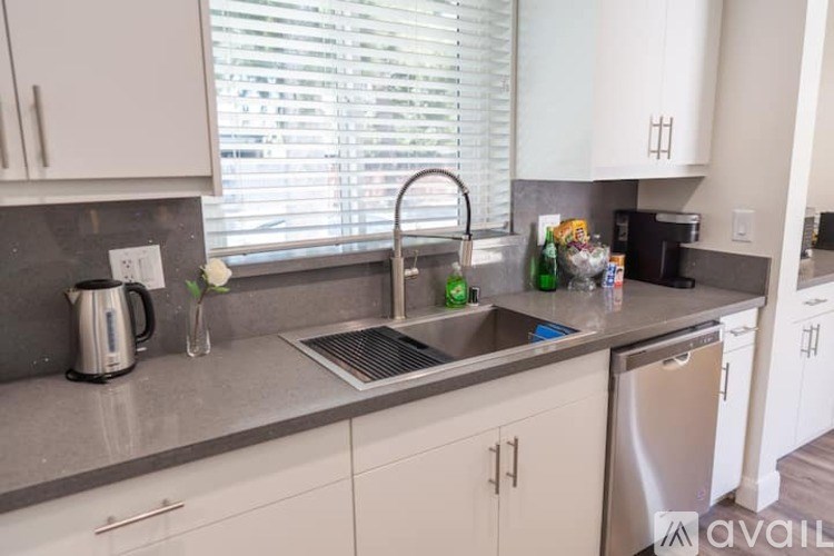 A kitchen with a sink, dishwasher, and a coffee maker.