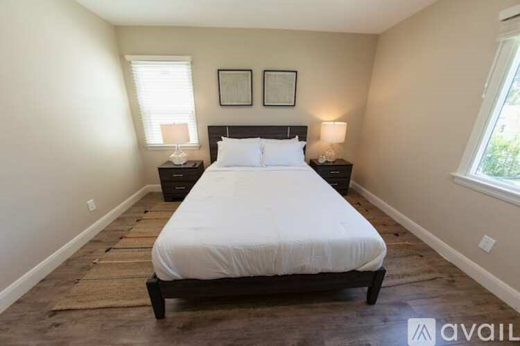 A bedroom with a large bed and two lamps.