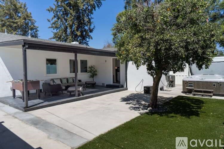A house with a patio and a tree in front of it.