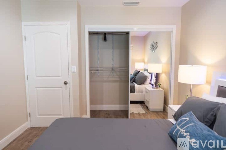 A bedroom with a bed, nightstand, and lamp.