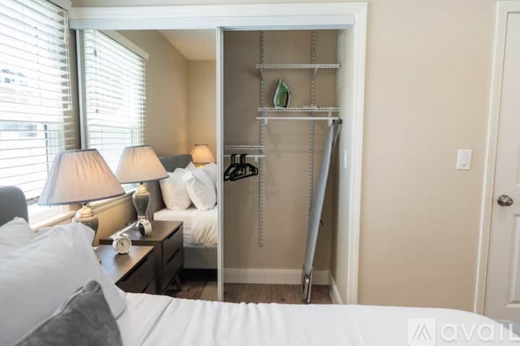 A bedroom with a bed, nightstand, and a closet with shelves.