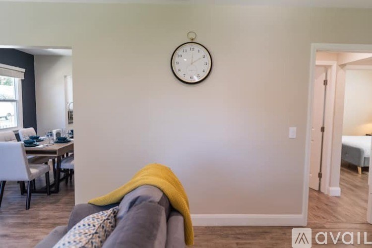 A living room with a grey couch and a yellow throw blanket.