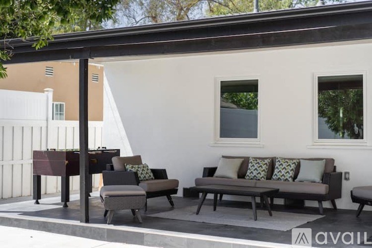 A patio with a couch, chairs, and a table.