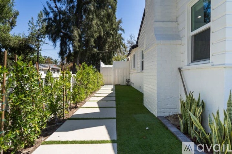 A white house with a garden in front.