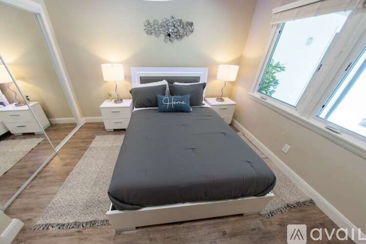 A bedroom with a large bed and two nightstands.