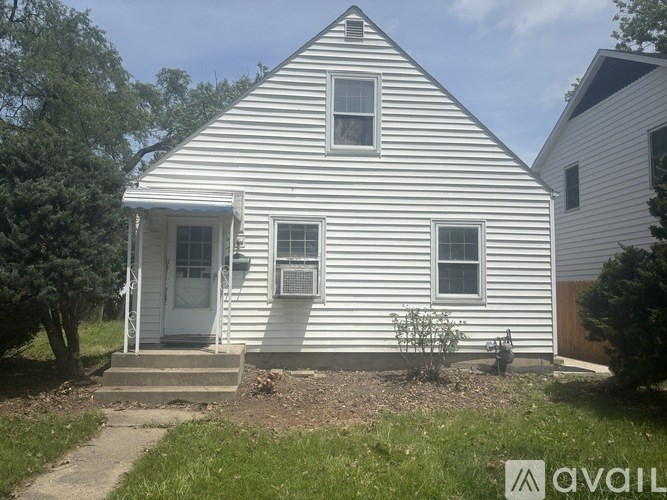 A white house with a striped siding and a small front porch.