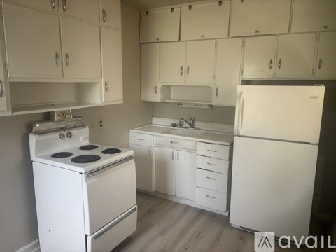 A kitchen with white appliances and cabinets.