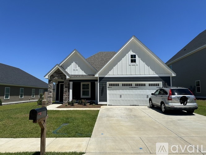 A house with a garage and a car parked in front.