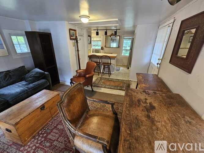 A living room with a black couch, a brown leather chair, and a wooden coffee table.