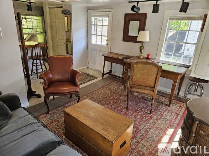 A room with a wooden desk and chairs.