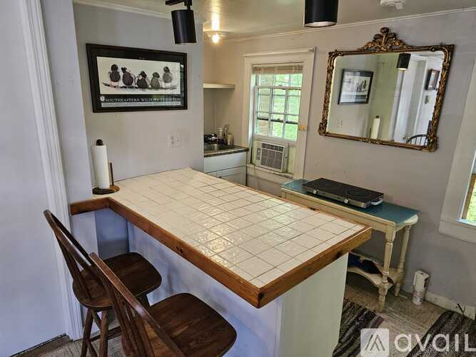 A kitchen with a table and chairs.