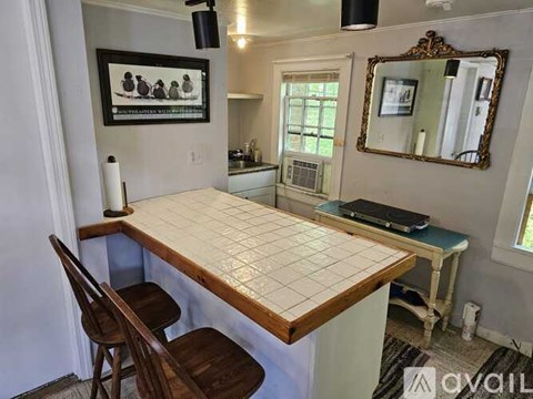 A kitchen with a table and chairs.