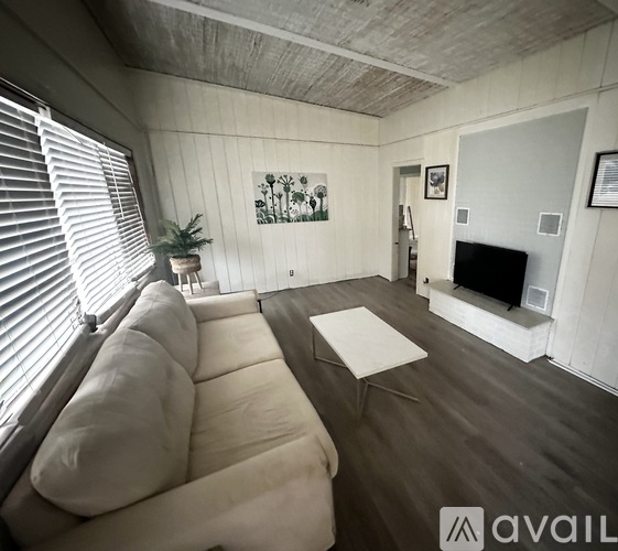 A living room with a white couch and a fireplace.
