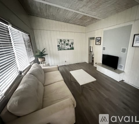 A living room with a white couch and a fireplace.