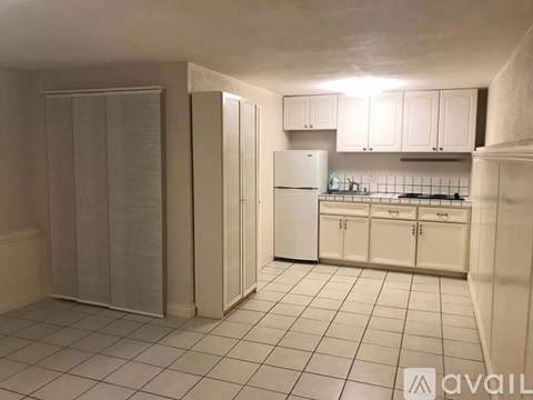 A kitchen with white cabinets and a white refrigerator.