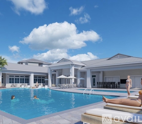 A woman is sunbathing by the pool at a resort.