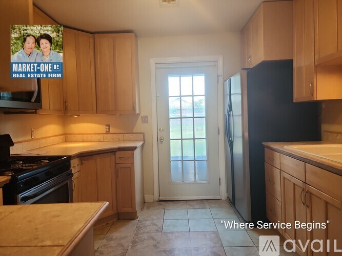 A room with two doors and one window, carpeted floor, and a ceiling fan.