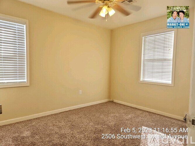 A room with a ceiling fan and carpeted floor.