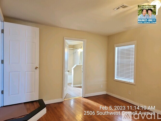 A room with a white door, a mirror, and a window with blinds.