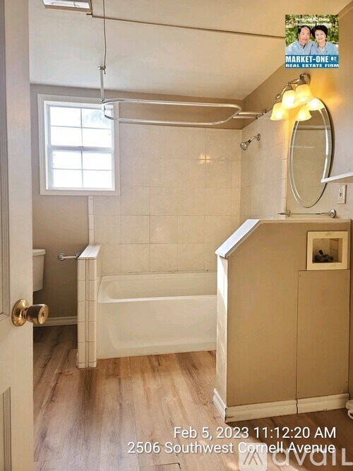 A bathroom with a tub, shower, and a window.