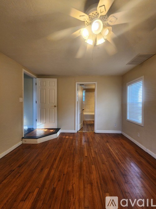 A room with wooden floors and a ceiling fan.