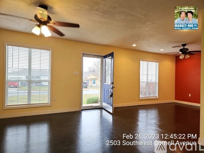A room with a ceiling fan and a door leading outside.