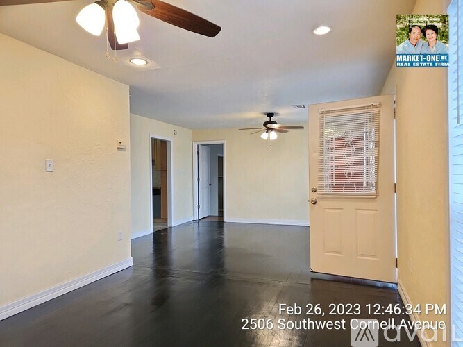 A room with a ceiling fan and a door leading to another room.