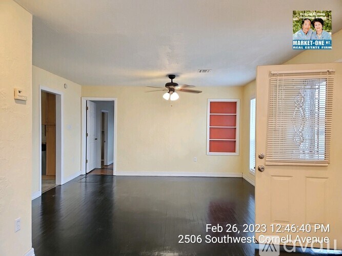 A room with a ceiling fan and a door leading to another room.