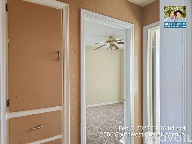 A room with a ceiling fan and a door leading to another room.