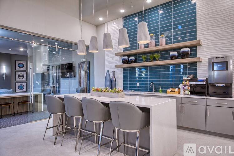 A modern kitchen with a bar area and chairs.