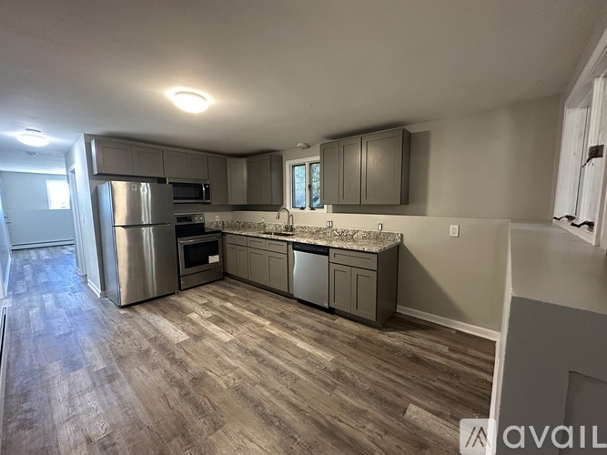 A kitchen with a refrigerator, oven, and microwave.