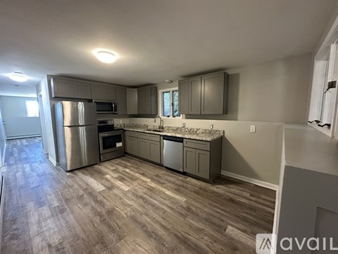 A kitchen with a refrigerator, oven, and microwave.