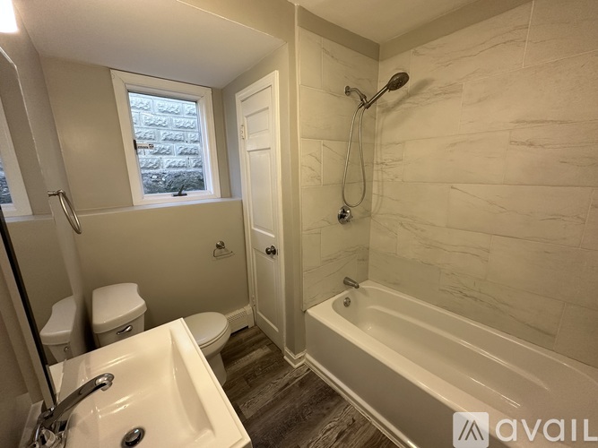 A bathroom with a tub, toilet, and sink.