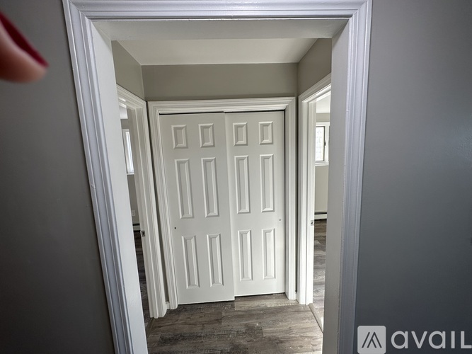 A white door in a room with a wooden floor.