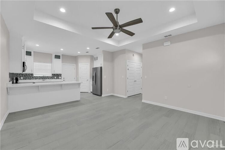 A spacious kitchen with a fan on the ceiling.