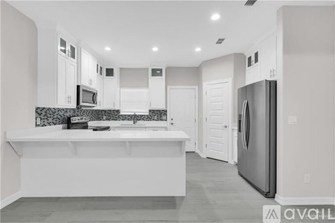A modern kitchen with white cabinets and a large island.