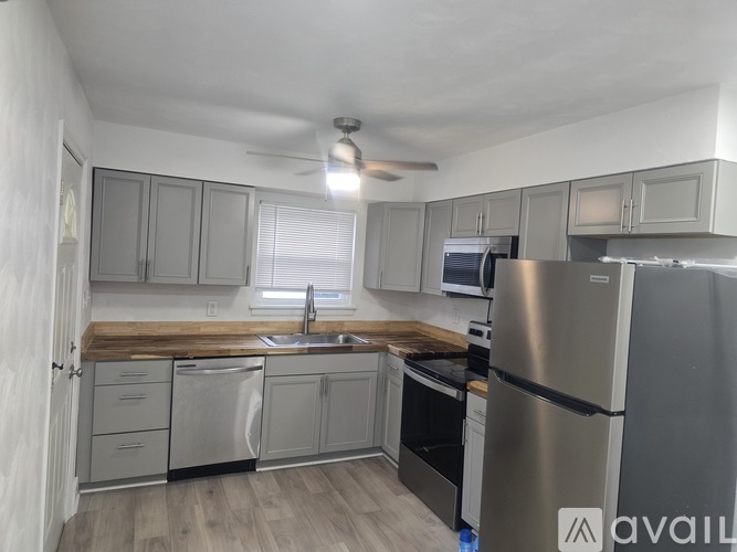 A kitchen with stainless steel appliances and wooden countertops.
