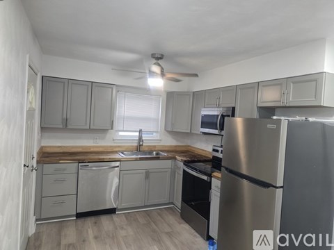 A kitchen with stainless steel appliances and wooden countertops.