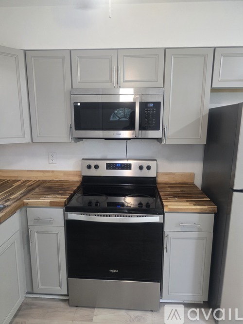 A kitchen with a black stove top oven and white cabinets.