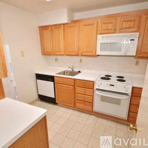 A kitchen with wooden cabinets and white appliances.