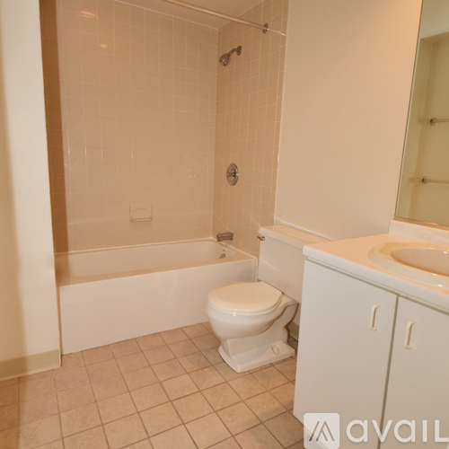 A white toilet sits next to a bathtub in a bathroom.