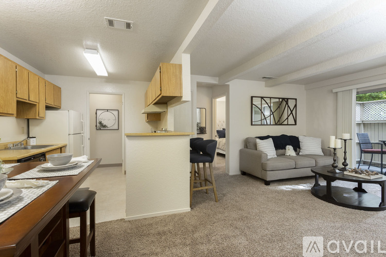 A living room with a couch, chair, and a dining table with chairs.