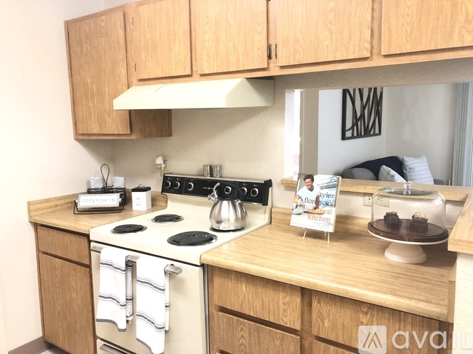 A kitchen with wooden cabinets and a white stove top.